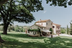 an exterior view of a house with a tree at Agriturismo Qui Voglio in Monte Roberto