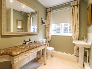 a bathroom with a sink toilet and a mirror at The Gate House in Colchester