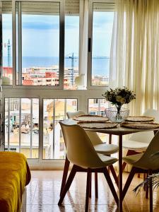 comedor con mesa, sillas y ventanas en Iris Vistas Sea & Sun Benalmadena, en Benalmádena