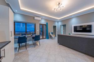 a large room with a kitchen and a bar with a tv at Luxury Sea View Apartment in Kolimvari in Kolymvari