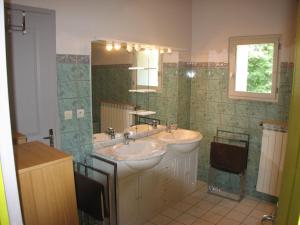 La salle de bains est pourvue de 2 lavabos et d'un miroir. dans l'établissement Domaine Saint-Joly, à Lasbordes