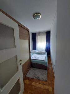 a small room with a bed and a window at Apartman LAURA in Zagreb