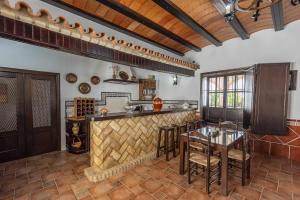 una cucina con bar, tavolo e sedie di Casa Rural Villa Cerro Mena a La Lantejuela