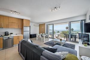 a kitchen and living room with a couch and a table at Apartamento Vista Mar - Arte Nova Fuseta in Fuzeta