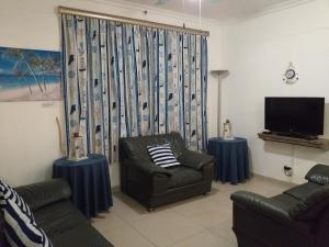 a living room with a couch and a television at Afsaal Sea view apartments in Amanzimtoti