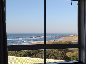 a view of the ocean from a window at Afsaal Sea view apartments in Amanzimtoti