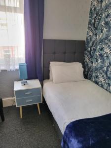 Un dormitorio con una cama y una mesa con un ordenador. en Talbot House, en Blackpool
