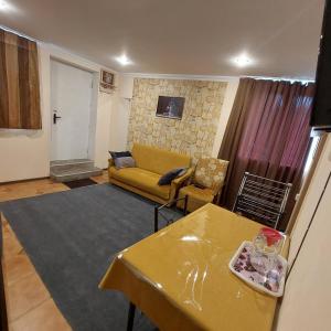 a living room with a yellow couch and a table at Buddha apartment in Tbilisi City