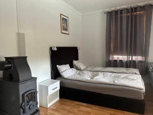 małą sypialnię z łóżkiem i kuchenką w obiekcie Oslo House, Nedre Kjellerstuvei, First floor, Twin Room w mieście Lillestrøm
