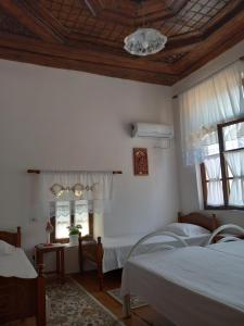 1 dormitorio con 2 camas y 2 ventanas en Guesthouse & hostel Lorenc, en Berat