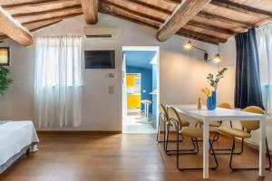 シエナにあるMimosa- Loft elegante con terrazza nel centro di Sienaのテーブルと椅子とベッドのある寝室