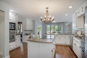 a kitchen with white cabinets and a chandelier at The Big Blue Lakehouse in Berrien Springs