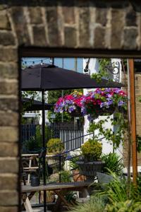 a patio with a table with flowers and an umbrella at The Bramley House Hotel in Chatteris