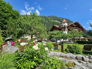 a garden with flowers in front of a building at Hotel Edenlehen in Mayrhofen