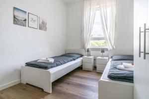 um quarto com 2 camas e uma janela em Nice Apartment in Offenbach a. M. em Offenbach