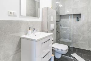 uma casa de banho com um lavatório, um WC e um chuveiro em Nice Apartment in Offenbach a. M. em Offenbach