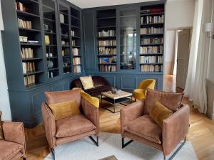 ein Wohnzimmer mit Stühlen und Bücherregalen in der Unterkunft Manoir de Villamont in Savigny-lès-Beaune