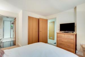 a bedroom with a bed and a television on a dresser at Spacious 2 bed 2 bath Kings Cross Apartment in London