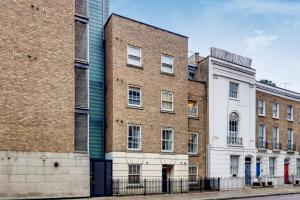 a large brick building next to a white building at Spacious 2 bed 2 bath Kings Cross Apartment in London
