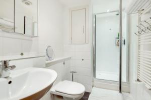 a white bathroom with a sink and a toilet at Spacious 2 bed 2 bath Kings Cross Apartment in London