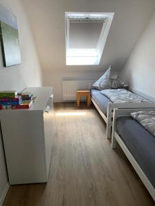 a bedroom with a bed and a desk and a window at Landhaus "Alte Welt" Nordseeküste in Osteel