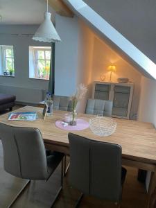 uma mesa de madeira com cadeiras e uma sala de jantar em Landhaus "Alte Welt" Nordseeküste em Osteel