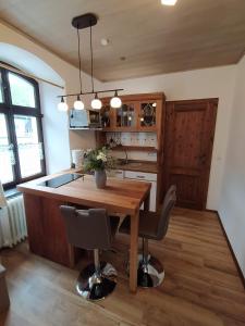 a kitchen with a wooden table and some chairs at Ferienwohnung Sauerland Burgfenster in Lennestadt