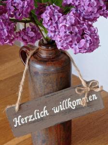 a vase filled with purple flowers sitting on a table at Ferienwohnung Sauerland Burgfenster in Lennestadt