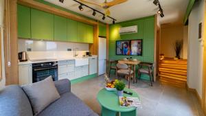 cocina con armarios verdes, sofá y mesa en Pier House Hotel, en Kalkan