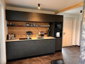a kitchen with black cabinets and a counter top at Chalet Deluxe in Freyung