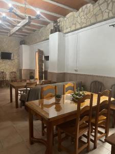 une salle à manger avec des tables et des chaises en bois dans l'établissement El Salao, à Olvera
