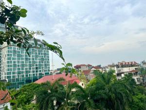 a city skyline with a tall building and palm trees at Dahlia Homestay Tay Ho in Hanoi