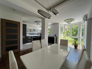 cocina y comedor con mesa blanca y sillas en Bagoly Apartman, en Eger