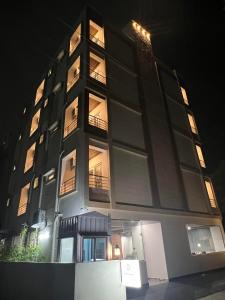 un palazzo alto di notte con le luci accese di Palladium Luxury Suites Financial District Unit I a Hyderabad