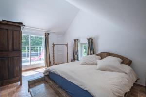 Herbignac的住宿－Entre Mer et Brière - Piscine Partagée，一间卧室设有一张床和一个大窗户