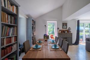 uma sala de jantar com uma mesa longa e estantes em Entre Mer et Brière - Piscine Partagée em Herbignac