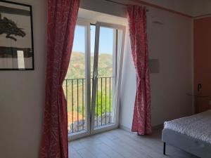 a bedroom with a door open to a balcony at Un Capriccio - Mirto in Aieta