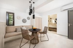 a living room with a table and chairs and a couch at Mnḗmē Suites & Villas in Kastrí