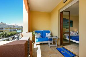 einen Balkon mit einem blauen Stuhl und einem Tisch in der Unterkunft Uno sguardo sul mare - Apartment - in Quartu SantʼElena