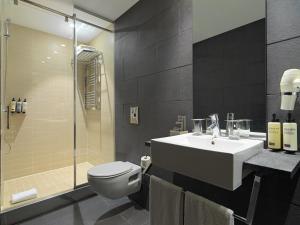 a bathroom with a sink and a toilet and a shower at H10 Casanova in Barcelona