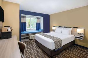 a hotel room with a large bed and a window at Microtel Inn & Suites by Wyndham Dry Ridge in Dry Ridge