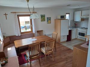 eine Küche und ein Esszimmer mit einem Holztisch und Stühlen in der Unterkunft Ferienhaus Sapplerhof in Millstatt