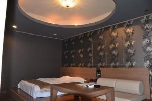 SōgayatoにあるHotel Takao Asielの天井が特徴の客室で、ベッド1台、テーブルが備わります。