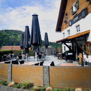 un restaurante con mesas y sombrillas frente a un edificio en SONNE Wilhams en Missen-Wilhams