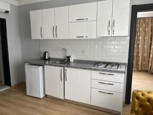 a white kitchen with white cabinets and a stove at CLOUDS Atapark in Soğuksu