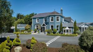 a large blue house with a driveway at Summerhill House Hotel in Enniskerry