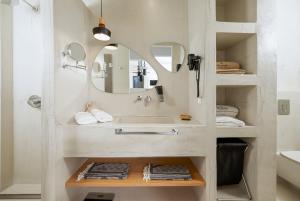 a bathroom with a sink and a mirror at Mnḗmē Suites & Villas in Kastrí