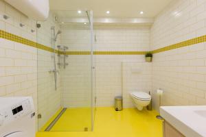 a bathroom with a glass shower and a toilet at Pastel paradise with a ray of sunshine in Budapest