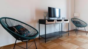 Habitación con 2 sillas y mesa con TV. en Italianway - Luigi Savoia 24, en Milán