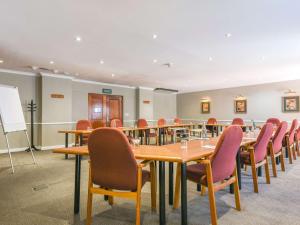 uma sala de conferências com uma mesa longa e cadeiras em Mercure Hotel Bedfordview em Joanesburgo